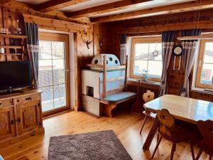 ein Esszimmer mit einem Tisch und einem TV in einer Hütte in der Unterkunft Musi Appartements in Schönberg im Stubaital