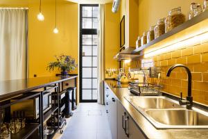 a kitchen with yellow walls and a sink at Amazinn Places EVI Apartments in Valencia