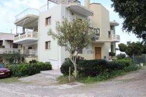a white building with a tree in front of it at Kallia's Modern Apartment in Kissamos
