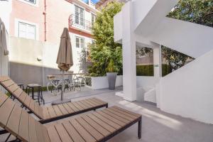 um pátio exterior com uma mesa e um guarda-chuva em The Lx Hill em Lisboa