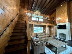 a living room with a staircase and a couch and a table at Creekfront Lodge: Brand new! in Pigeon Forge