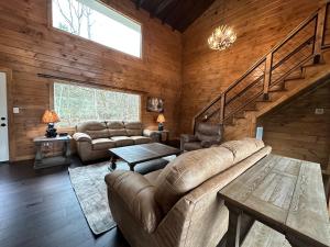 a living room with a couch and a staircase at Creekfront Lodge: Brand new! in Pigeon Forge