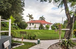 a house with a green lawn and a tree at Harbour View Boutique Hotel & Yoga Retreat in Belize City