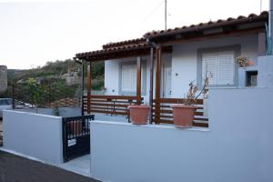 una casa blanca con dos macetas en el balcón en Zorbas House en Heraclión