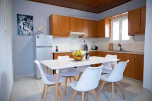eine Küche mit einem weißen Tisch und weißen Stühlen in der Unterkunft Zorbas House in Iraklio