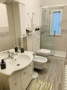 a bathroom with a sink and a toilet and a shower at La casa nel verde con piscina in Polverara