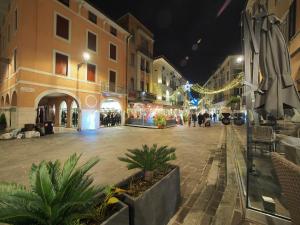 a city street at night with people walking around at From Pedrotti in Desenzano del Garda