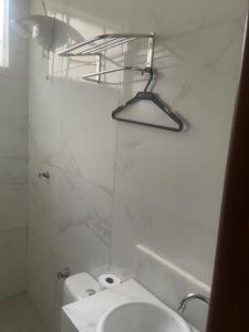 y baño blanco con lavabo y ducha. en El Nassr suits, en Goiânia