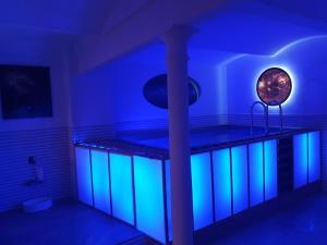 a room with a bed with blue and green lights at Loft Wellness City Center in Leipzig