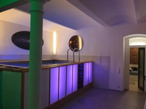 a room with a green column and purple lighting at Loft Wellness City Center in Leipzig