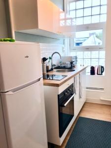 a kitchen with a white refrigerator and a stove at T2 Le Moderne • Netflix • Parking • Gare in Évreux