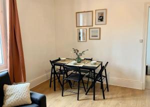 una mesa de comedor negra y sillas en una habitación en T2 Le Moderne • Netflix • Parking • Gare, en Évreux
