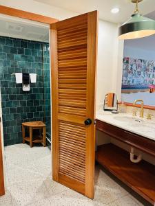 baño con lavabo y puerta de madera en King Christian Hotel, en Christiansted