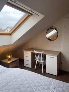 a bedroom with a bed and a desk and a window at Ferienwohnung Fam. Albert in Heuchelheim-Klingen