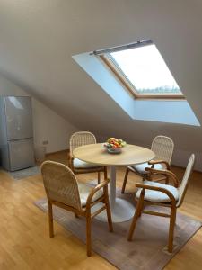 a table and chairs in a room with a skylight at Ferienwohnung Fam. Albert in Heuchelheim-Klingen