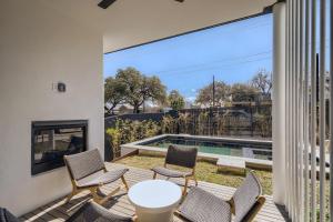 um pátio com cadeiras, uma mesa e uma piscina em Modern House Downtown View with Pool & Hot Tub em Austin