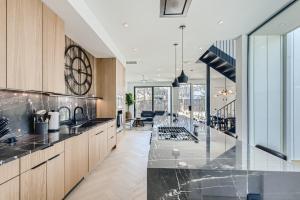 uma cozinha com bancadas pretas e armários de madeira em Modern House Downtown View with Pool & Hot Tub em Austin