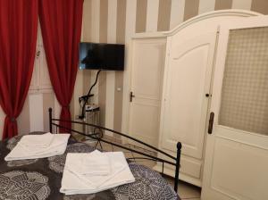 a bedroom with two beds with red curtains at La piccola Posta di Cortona in Cortona
