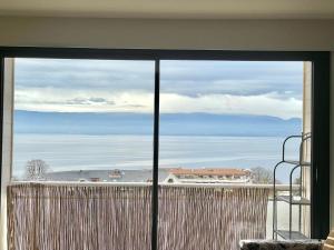 a view of the ocean from a living room window at Le Turgot, proche thermes in Thonon-les-Bains