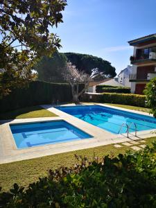 a swimming pool in a yard next to a building at Apartamento con piscina L' Áncora in Calella de Palafrugell