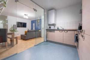 a kitchen and a living room with a couch at Loft mit Balkon im Historischen Altbau am Marktplatz - 75qm, DisneyPlus, 300mbs Internet in Chemnitz