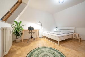 1 dormitorio con cama, mesa y alfombra en Loft mit Balkon im Historischen Altbau am Marktplatz - 75qm, DisneyPlus, 300mbs Internet, en Chemnitz