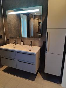 a bathroom with a white sink and a mirror at Torghatten bnb in Brønnøysund