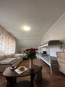 VIP hostel في موكاشيفو: غرفة بسريرين بطابقين وطاولة مع ورد