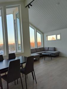 Habitación grande con mesas, sillas y ventanas. en Torghatten bnb, en Brønnøysund