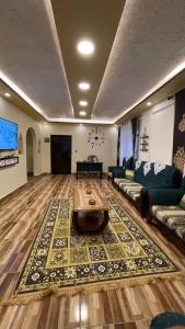 Ad Deir Guesthouse في وادي موسى: غرفة معيشة كبيرة مع أريكة وطاولة
