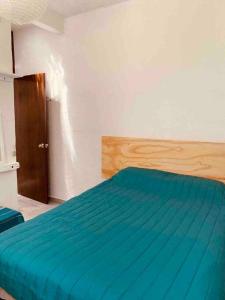 1 dormitorio con 1 cama con edredón azul en Casita cerca de T1 y T2 del aeropuerto y Foro Sol, en Ciudad de México