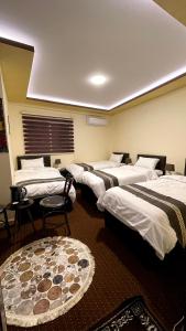 a row of beds in a room with a room with at Ad Deir Guesthouse in Wadi Musa