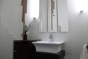 Baño blanco con lavabo y espejo en SmartTrip, en Sevilla