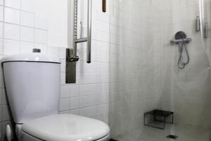 y baño blanco con aseo y ducha. en SmartTrip, en Sevilla