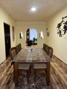 Ad Deir Guesthouse في وادي موسى: غرفة طعام مع طاولة مع كراسي