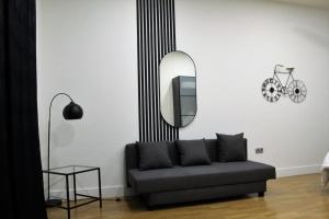 a living room with a black couch and a mirror at SmartTrip in Seville