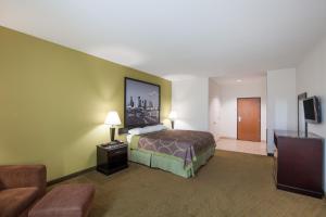 a hotel room with a bed and a flat screen tv at Scottish Inns and Suites - La Porte in La Porte