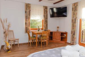 a room with a table and chairs and a television at Apartments PIT Zdole in Kozje