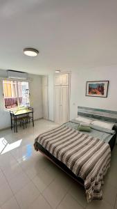 Un dormitorio con una cama y una mesa dentro. en Estudio Río Caramel, en Torremolinos