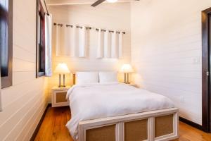 een slaapkamer met een groot wit bed met 2 lampen bij Paradise Cottage 3 bedroom 4 beds, 1 Full Bath - Private in San Pedro