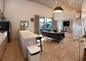 a kitchen with a couch and a table in a room at Boathouse La Bougainvillea cottage in Governorʼs Harbour