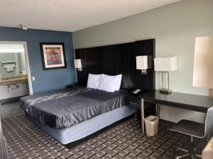 um quarto de hotel com uma cama e uma secretária em Executive Inn em Pelham