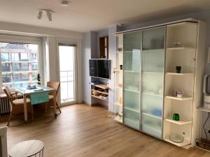 a living room with a desk and a large glass cabinet at Sunny studio with seaview in Knokke-Heist