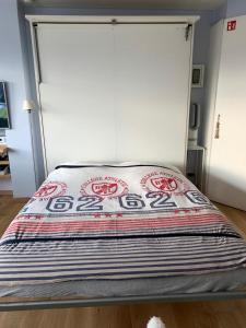 a bed in a room with a large window at Sunny studio with seaview in Knokke-Heist