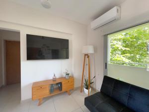 a living room with a couch and a tv at Departamento Moderno La Plata, Plaza España in La Plata