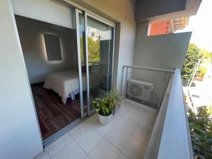 Un balcón de una casa con una cama y una ventana en Departamento Moderno La Plata, Plaza España en La Plata
