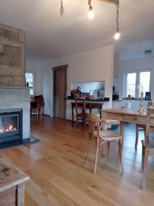 a living room with a fireplace and a table and chairs at le gîte des remparts in Aywaille