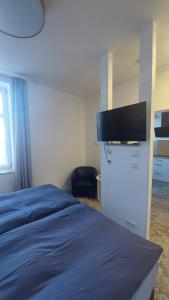 a bedroom with a bed and a tv on a wall at An der Stadtmauer in Halberstadt