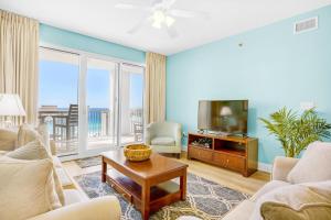 a living room with a tv and a couch and a table at Ariel Dunes I 1502 in Destin