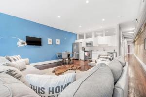 sala de estar con sofá blanco y pared azul en Stunning Old City 2 Bedroom - Elevator, Bay Windows en Filadelfia